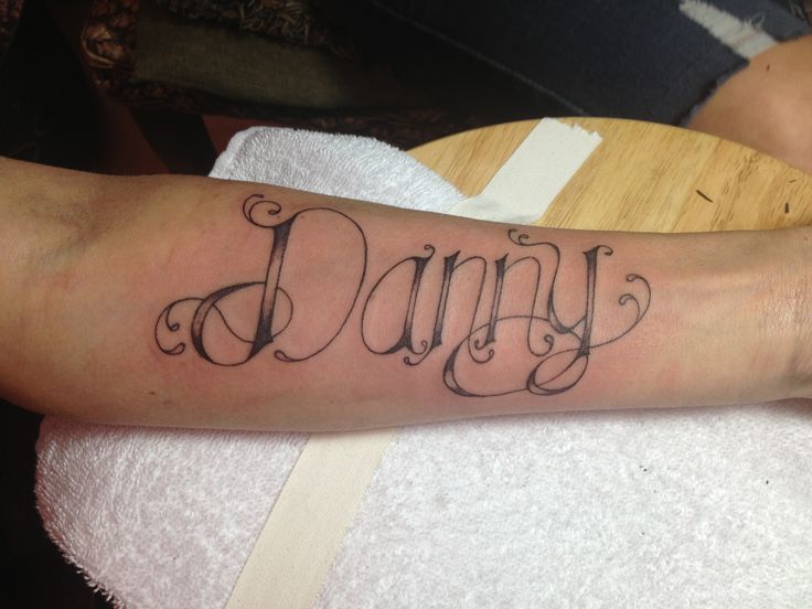 a person with a tattoo on their arm that says, dainty written in cursive font