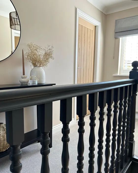 there is a mirror on the wall next to a black railing in this living room