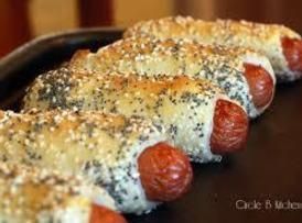 hotdogs wrapped in bread and sprinkled with sesame seeds