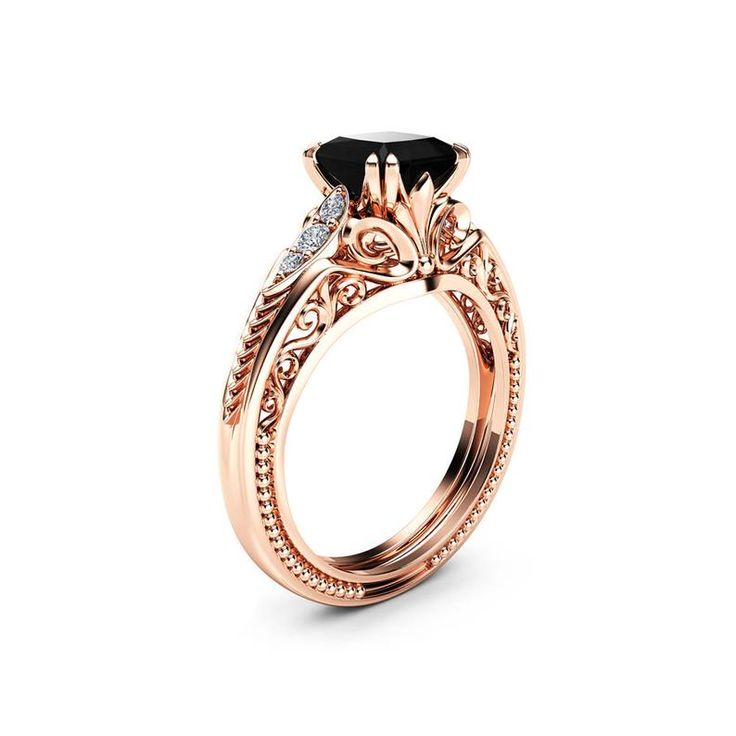 a rose gold engagement ring with an oval black diamond in the center and side stones