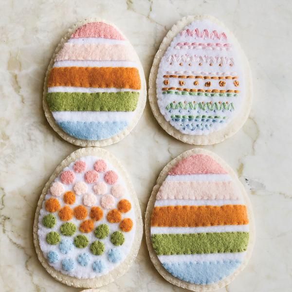 four decorated cookies sitting on top of a counter