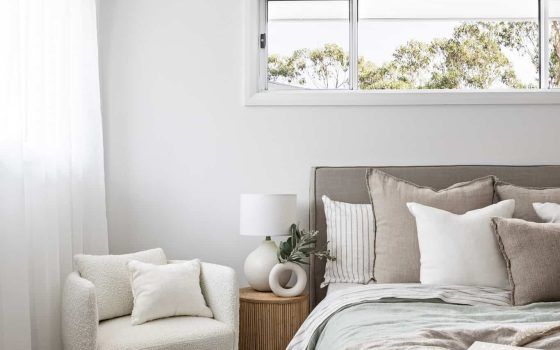 a bedroom with white walls and neutral bedding