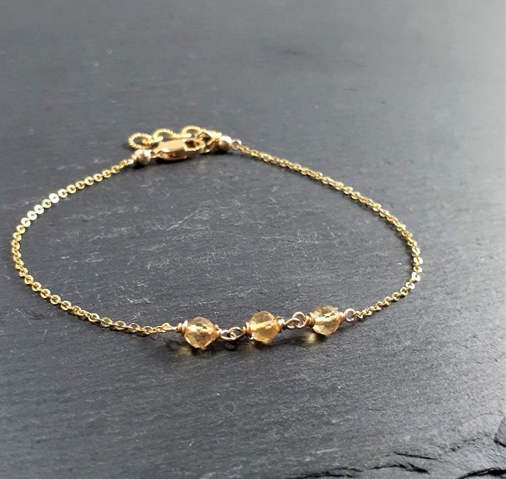 This beautiful handmade bracelet features 3 Genuine Golden Citrine gemstones wrapped in the metal of your choice. Dainty, minimal, and elegant, this bracelet is the perfect finishing touch to any style or event. Makes a great gift to add to any gemstone lover's collection. Perfect to gift for Christmas, Valentine's Day, Mother's Day, and more! Gemstone: Citrine Gemstone Size: 3.0 mm Gemstone Color: Golden Yellow Gemstone Shape: Rondelle, Faceted Metal: 14k Gold Filled or Sterling Silver (Nickel Elegant Gold Citrine Crystal Bracelet, Minimalist Crystal Bracelet Gift, Minimalist Crystal Gemstone Bracelet Gift, Minimalist Gemstone Crystal Bracelet Gift, Handmade Minimalist Crystal Bracelet, Minimalist Crystal Gemstone Bracelet For Gift, Elegant Citrine Wire Wrapped Jewelry, Minimalist Citrine Jewelry, Minimalist Citrine Jewelry As Gift