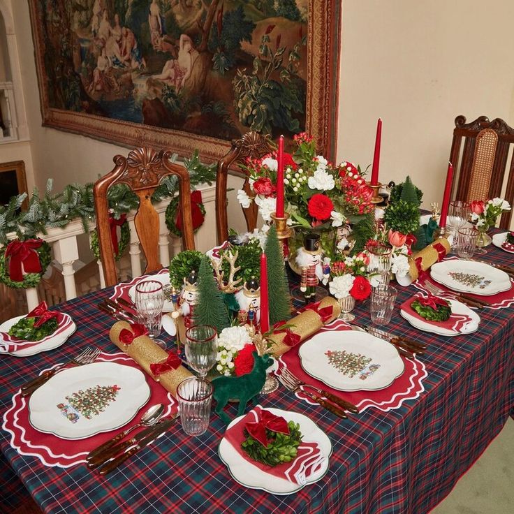 the table is set for christmas dinner with red and green decorations