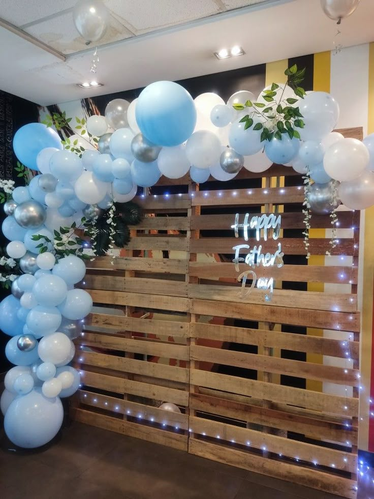 balloons and greenery decorate the entrance to a birthday party