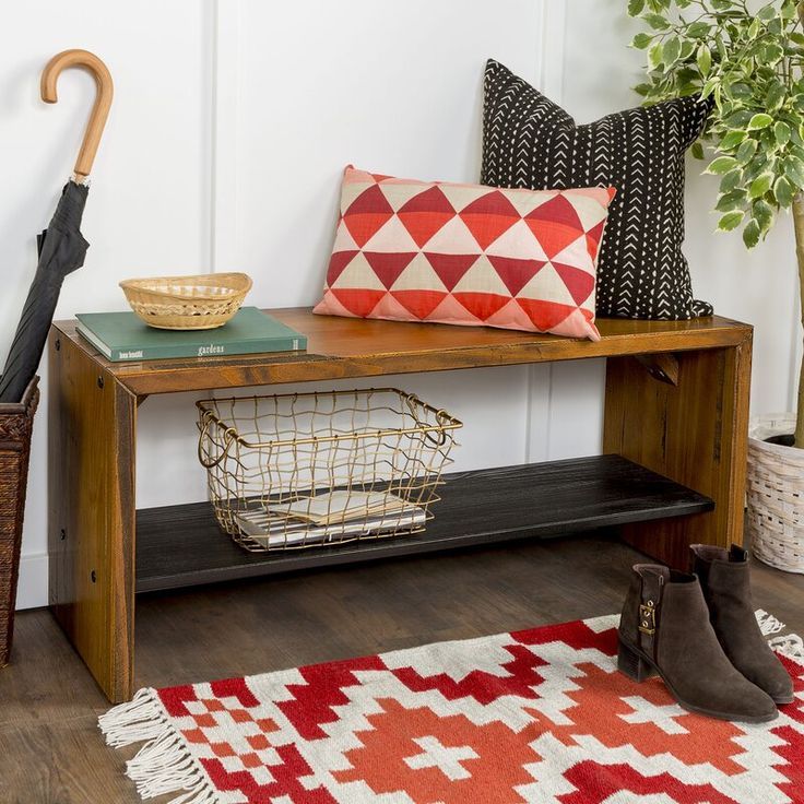 a wooden bench sitting on top of a hard wood floor next to a potted plant