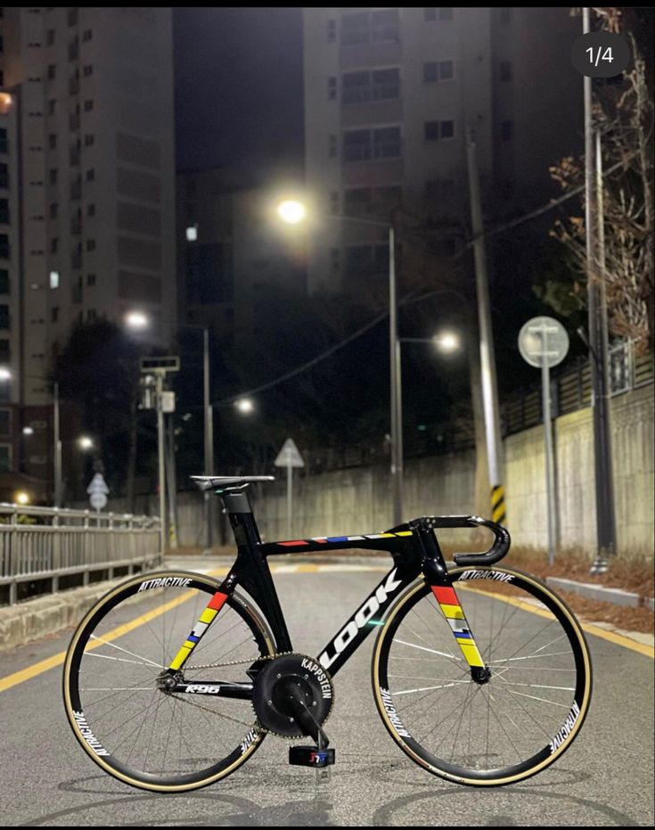 a bicycle parked on the side of a road at night