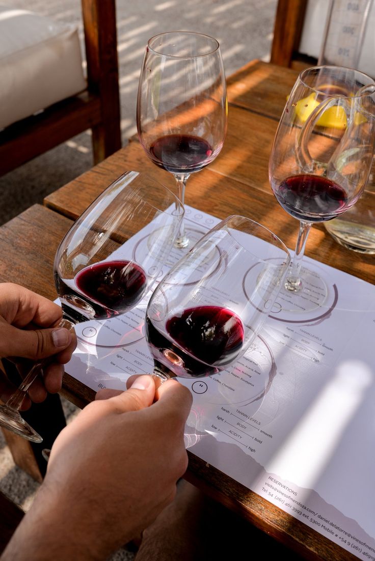 two glasses of wine sitting on top of a wooden table