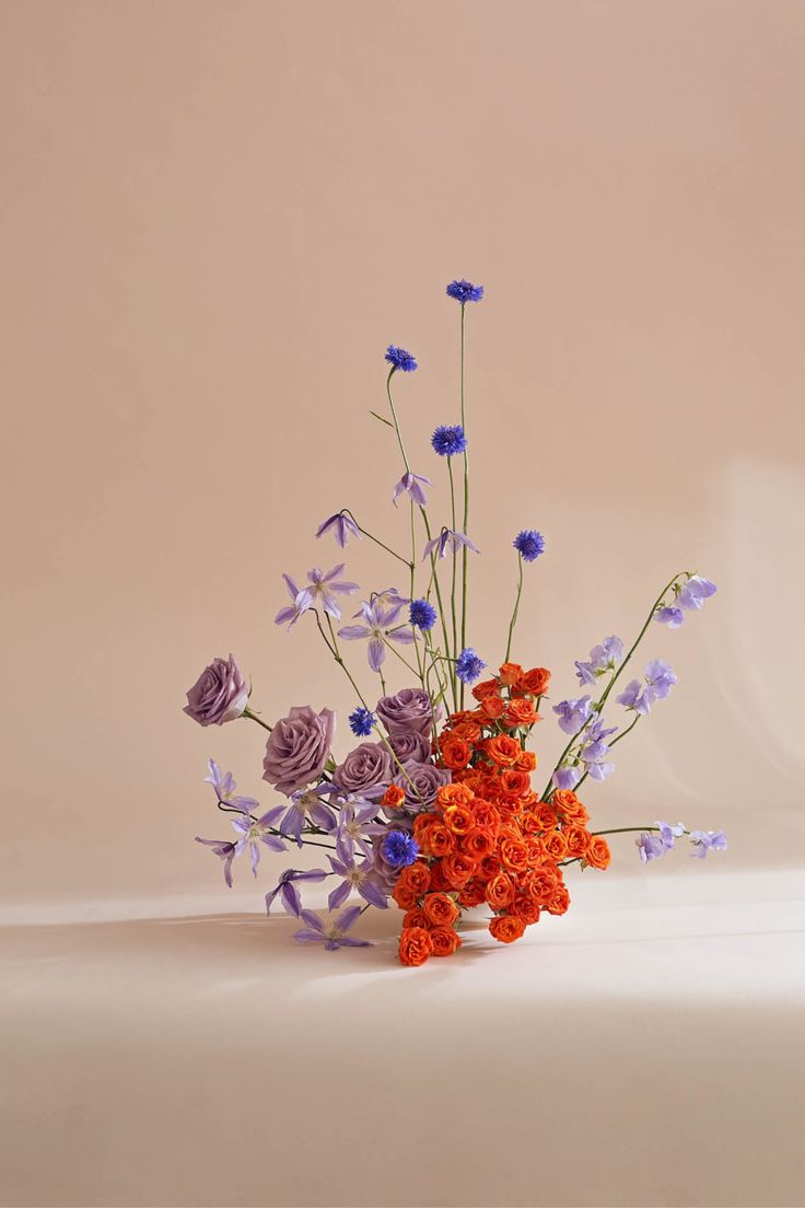 an arrangement of flowers in a vase on a table