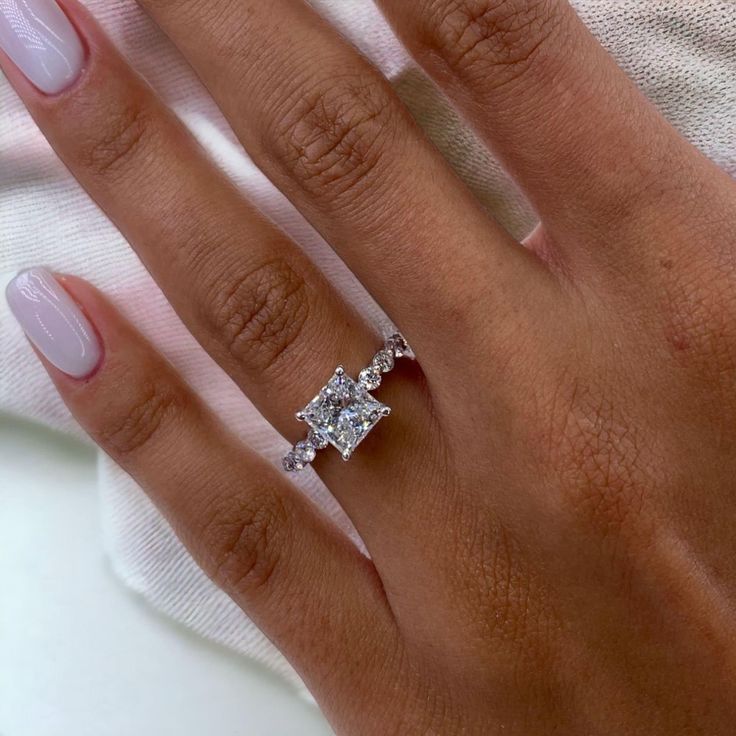 a woman's hand with two diamond rings on it