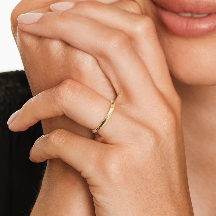 a close up of a person with a ring on their finger and her hand near her face