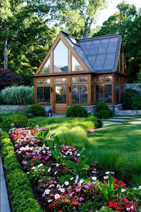 the house is surrounded by lush green grass and flowers