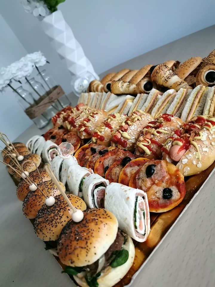 a table topped with lots of different types of sandwiches and buns covered in toppings