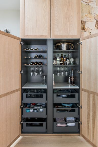 an open cabinet with many glasses and other items in the cupboards on both sides