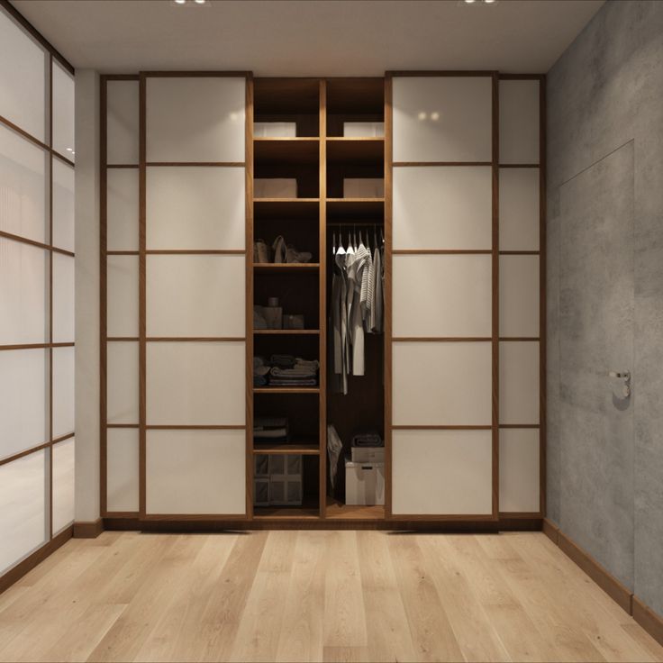 an empty closet with sliding doors and clothes hanging on the shelves in front of it