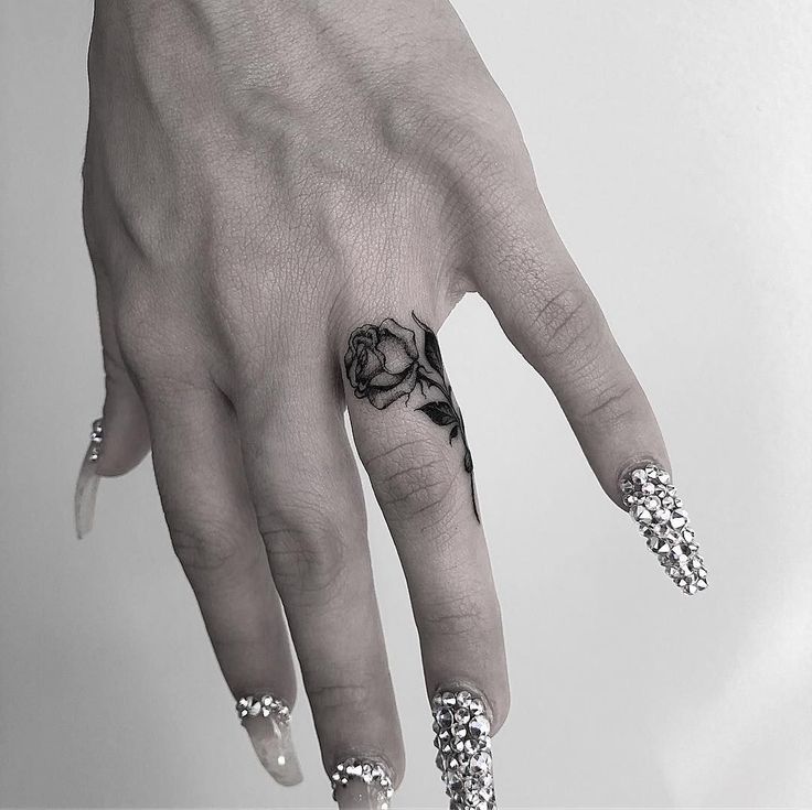 a woman's hand with black and white flowers on it