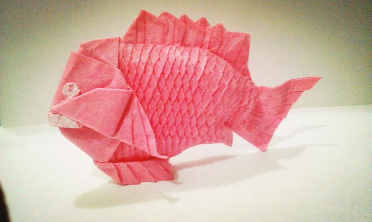 a pink paper fish sitting on top of a table