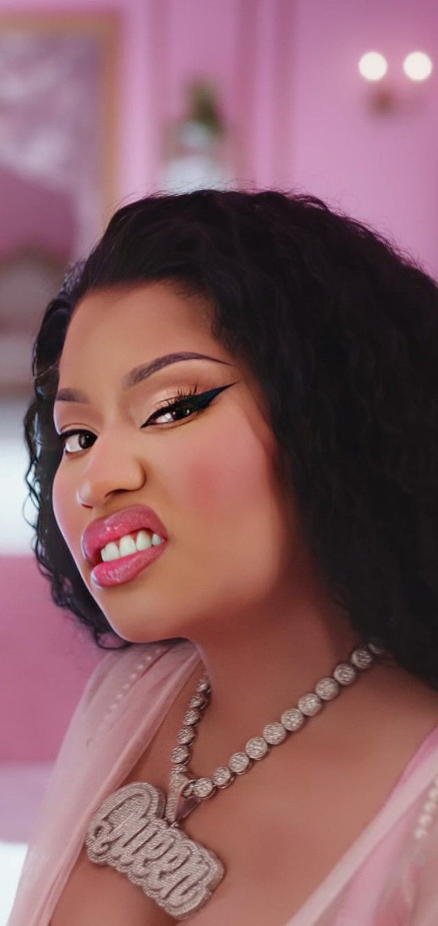 a woman with long black hair wearing a pink dress and pearls on her necklace is posing for the camera