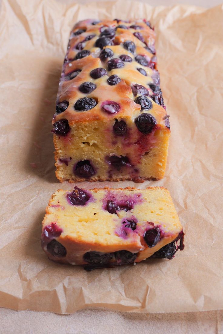 a loaf of blueberry bread sitting on top of a piece of wax paper