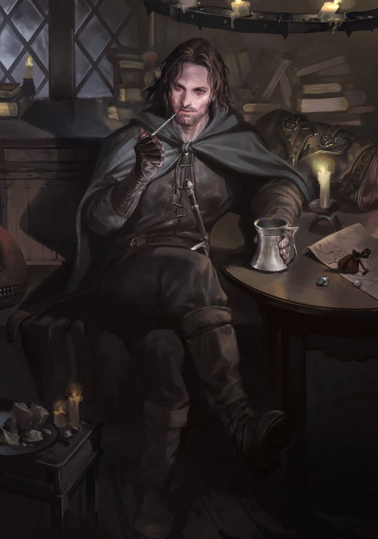 a man sitting at a table with a cup in his hand and wearing a cloak