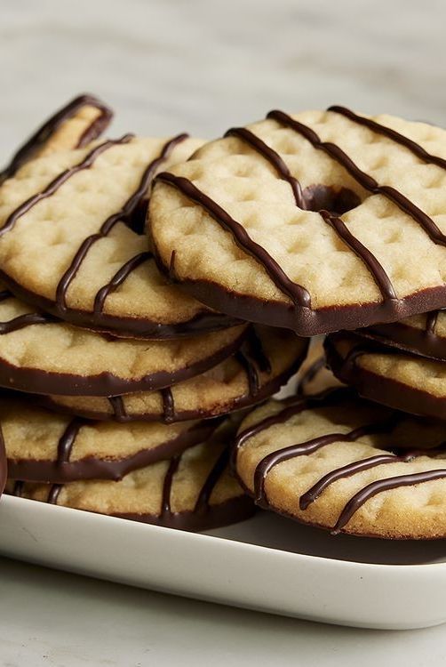 a white plate topped with cookies covered in chocolate