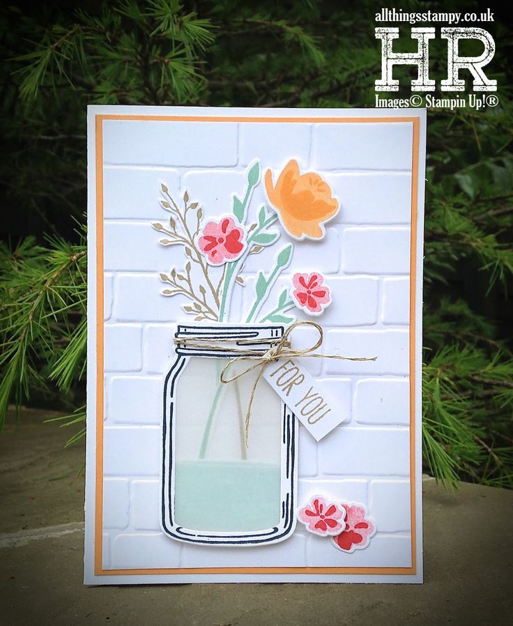 a card with flowers in a mason jar