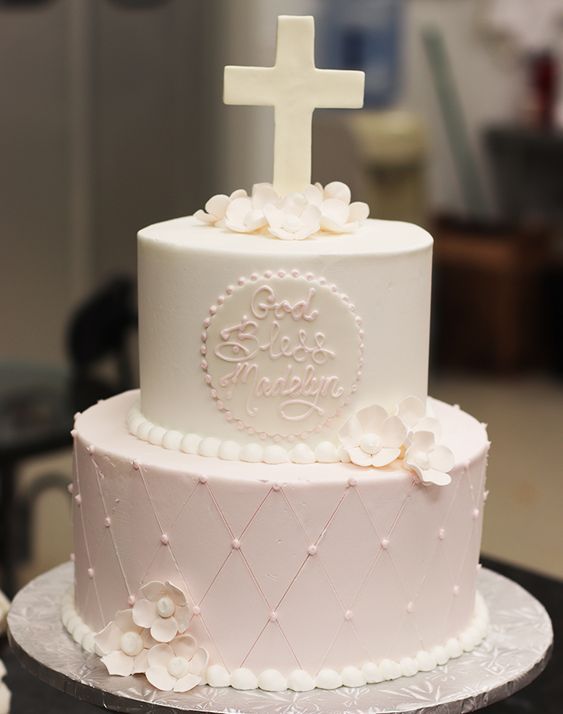 a white cake with flowers and a cross on top