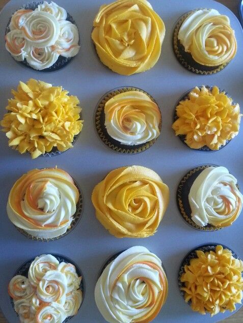 twelve cupcakes with yellow and white frosting flowers on them are arranged in a circle