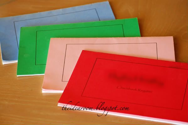 four different colored envelopes sitting on top of a wooden table