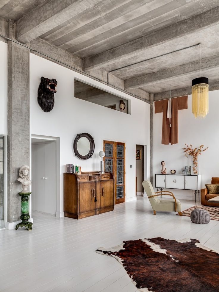 a living room filled with furniture and lots of wood accents on the walls, along with a cowhide rug