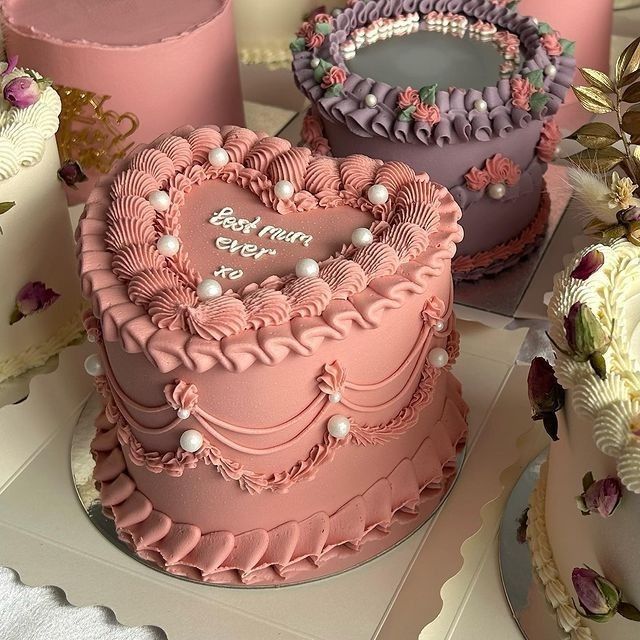 there are three cakes that have hearts on them, one is pink and the other is purple