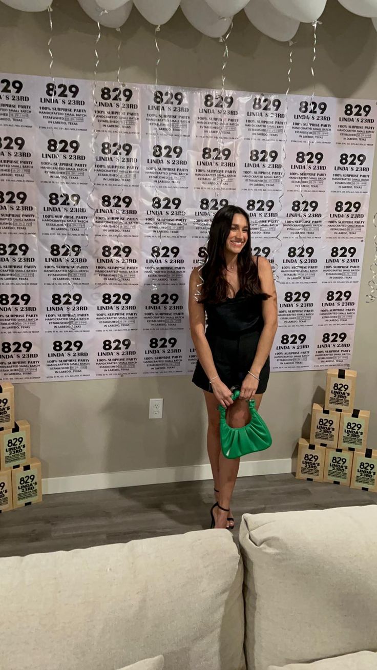 a woman standing in front of a wall with balloons