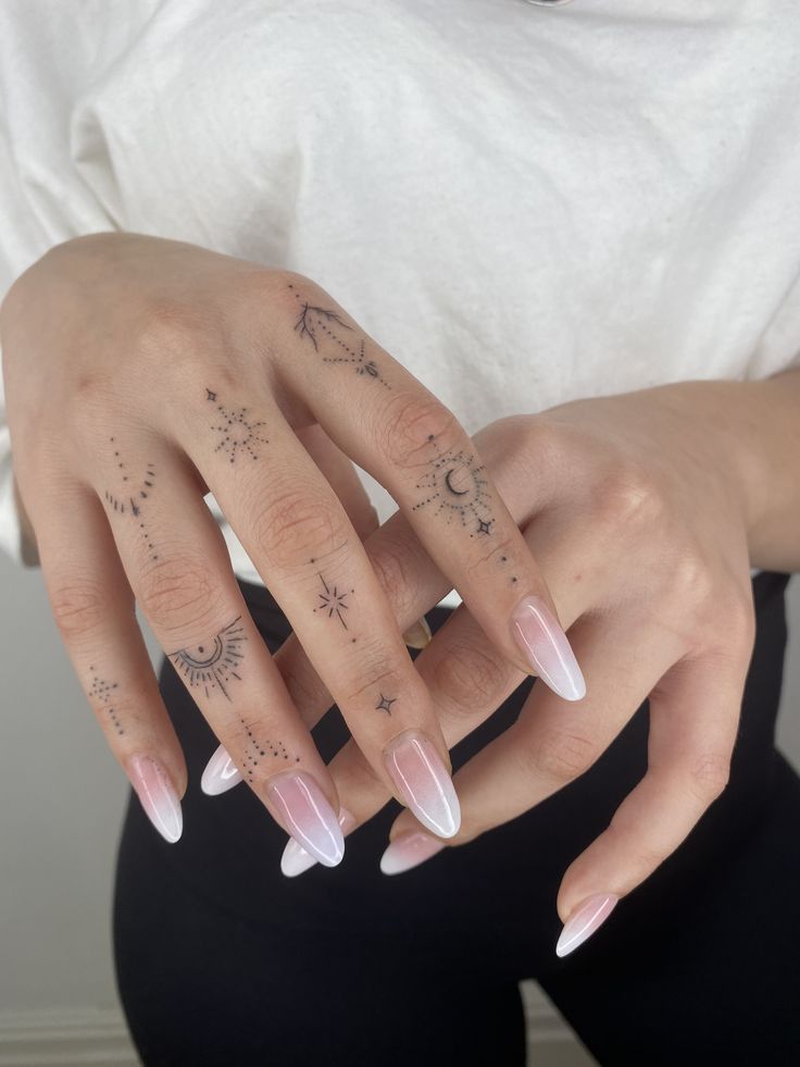 a woman's hands with white and pink manicures on them, holding onto her hand