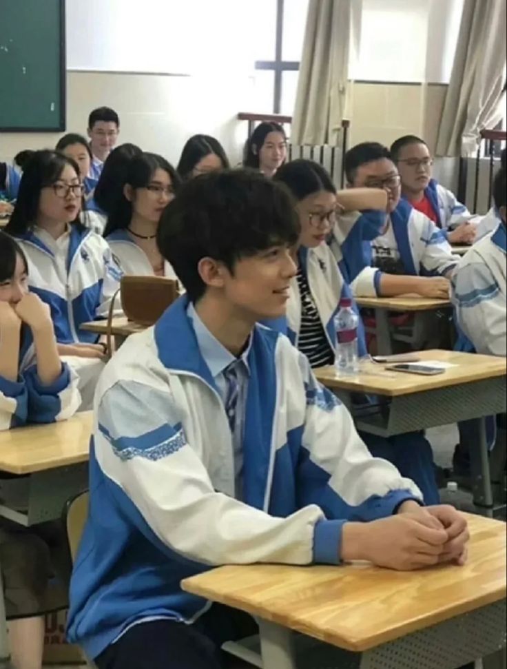 a group of people sitting at desks in a classroom