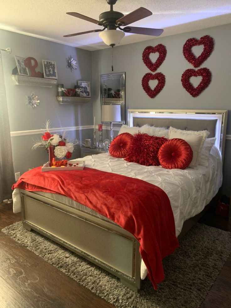 a bedroom decorated for valentine's day with red and white decor