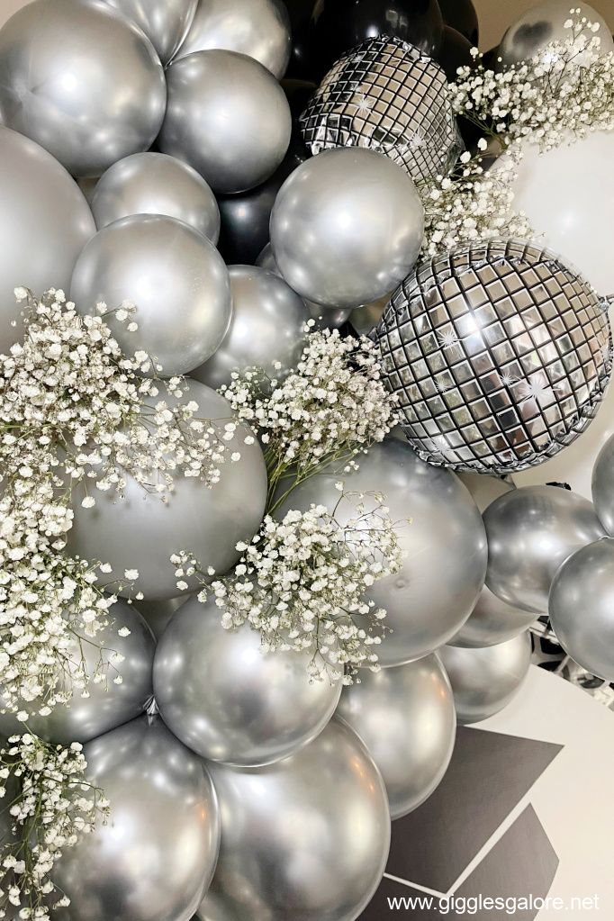 silver balloons and baby's breath flowers are on display