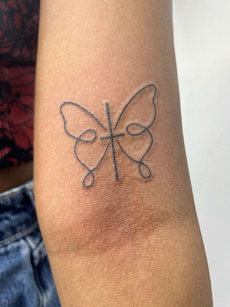 a small tattoo on the arm of a woman's left arm with a butterfly