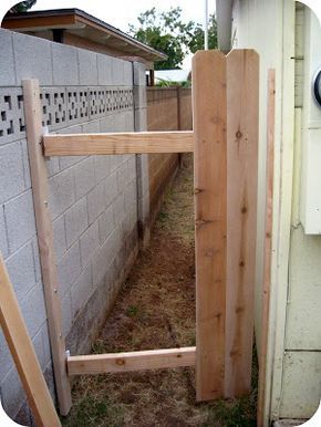 an unfinished wooden gate in front of a house