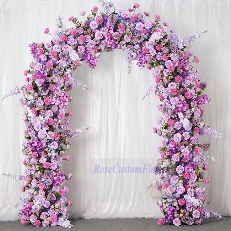 an arch made out of purple and pink flowers