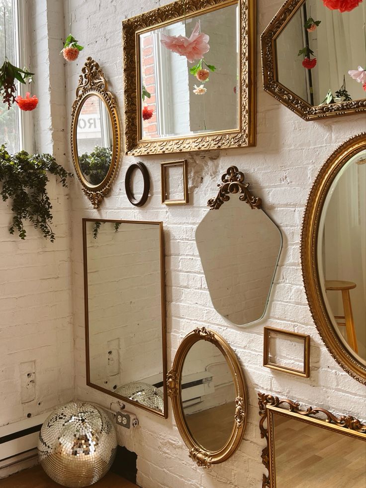 A brick wall with various shaped mirrors, a disco ball on the ground in the corner, and hanging flowers from the ceiling Disco Decor Aesthetic, Disco Ball Mirrors, Dit Disco Ball, Disco Ball Decor Bathroom, Bathroom Disco Ball, Disco Apartment Decor, Vintage Disco Ball Aesthetic, Disco Nursery, 70s Apartment Aesthetic