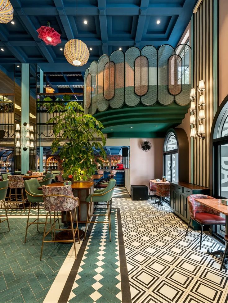 the interior of a restaurant with tables, chairs and potted plants on the floor