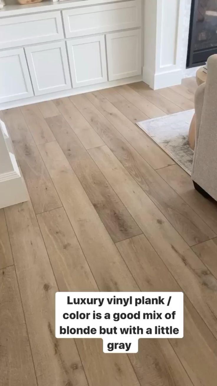 a living room with wood floors and white cabinets in the background, text reads luxury vinyl plank / color is a good mix of blonde but with a little gray