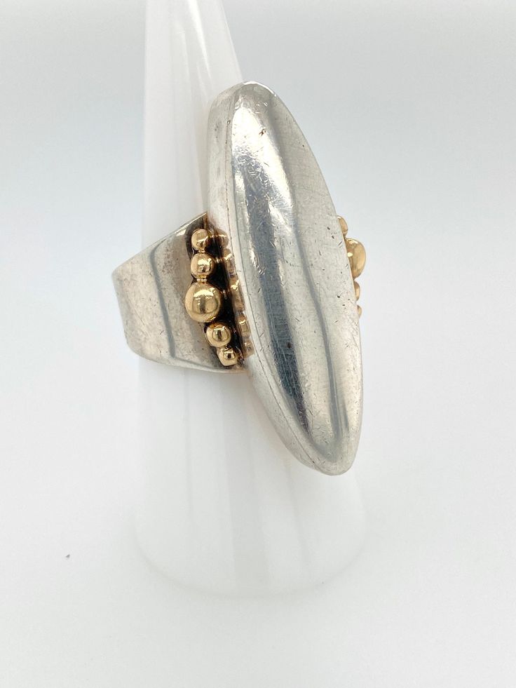 "Vintage Artisan Sterling Silver Oblong Ring with 14k Gold Accent -Very nicely made, handcrafted, artist signed -Large Sterling silver elongated lens shape with 14k gold bubble accents on each side -Ring is open at the shank, could be slightly adjusted in size if desired -Ring is size 8.25 -Ring is hallmarked \"Sterling\" \"14k\" and has an artists hallmark with a snake in the shape of a M or triangular wave -Ring face measures about 1.5\" x .75\" with a depth of .4\" -Total weight 11.8g -In goo Artisan Rings With Polished Finish For Formal Events, Artisan Rings With Polished Finish For Formal Occasions, Unique Polished Oval Rings, Modernist Hallmarked Oval Jewelry, Modernist Oval Gold Jewelry, Modern Oblong Jewelry For Anniversary, Unique Oval Rings With Polished Finish, Handmade Modernist Oval Rings, Modernist Oval Gold Rings