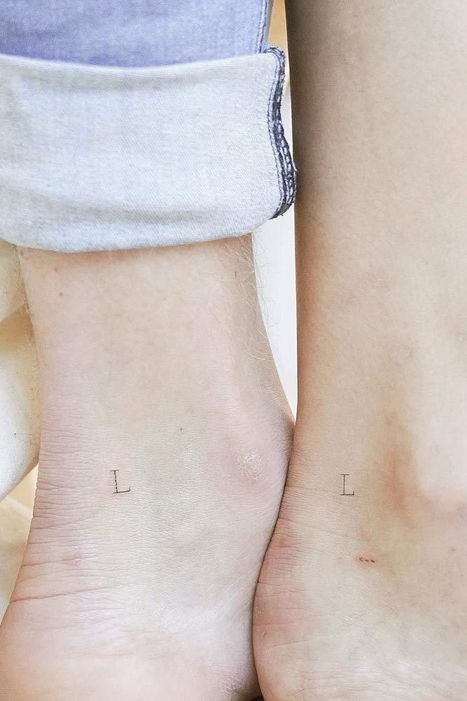 two people with small tattoos on their feet, one is holding the other's leg