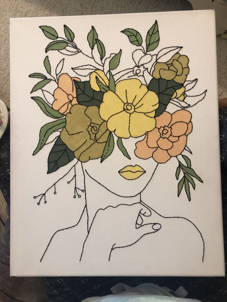 a drawing of a woman's face with flowers in her hair on a white canvas