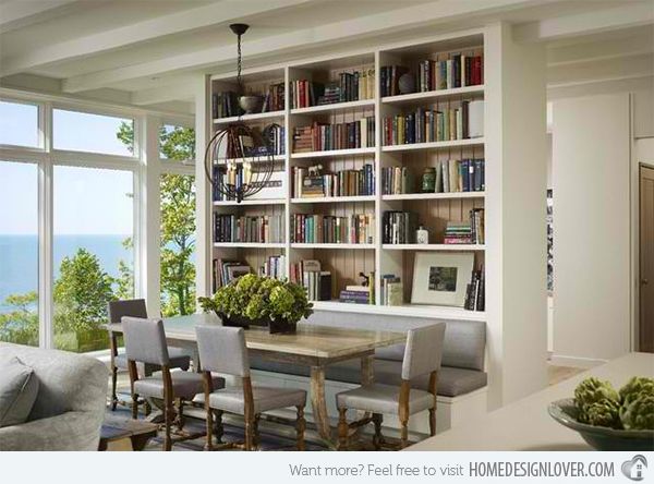 a living room filled with furniture next to a large window covered in bookshelves