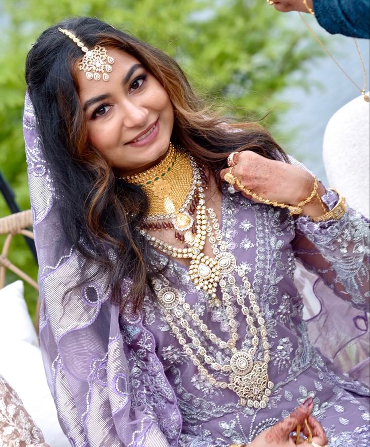 a woman in a purple dress with jewelry on her head