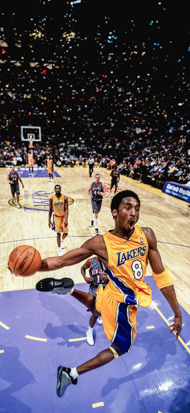 a basketball player is jumping up to dunk the ball in front of other players