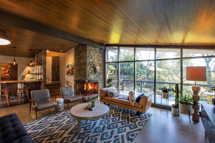 a living room filled with furniture and a fire place next to a large glass window