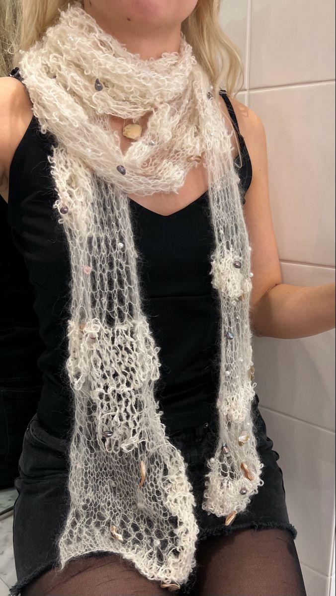 a woman is sitting on the toilet wearing a white scarf and black stockings with buttons